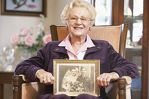 Senior woman holding an old wedding photo