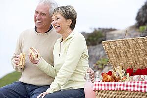 Couple Eating An Al Fresco Meal At The Beach