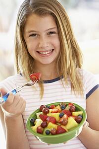 Young Girl Eating Fresh Fruit Salad