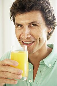 Mid Adult Man Drinking A Glass Of Orange Juice
