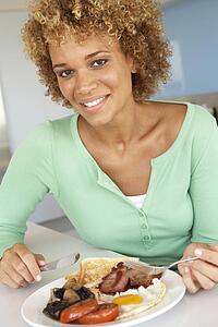 Mid Adult Woman Eating Unhealthy Fried Breakfast