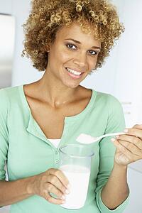 Mid Adult Woman Holding Dietary Supplements