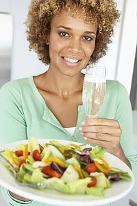Mid Adult Woman Holding A Wine Glass And Fresh Salad