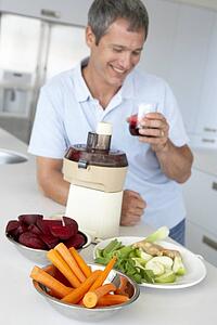 Middle Aged Man Making Fresh Vegetable Juice