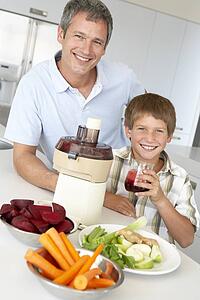 Father And Son Making Fresh Vegetable Juice