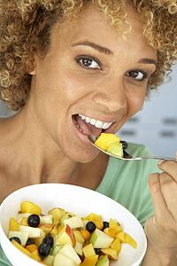 Mid Adult Woman Eating Fresh Fruit Salad
