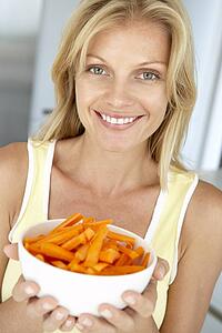 Mid Adult Woman Holding A Bowl Of Carrots