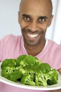 Middle Aged Man Holding A Plate Of Broccoli