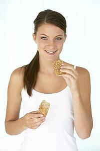 Young Woman Eating A Brown Bread Roll