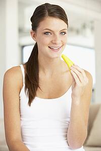 Young Woman Eating Fresh Pineapple