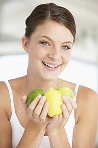 Young Woman Holding Fresh Fruit And Smiling At The Camera
