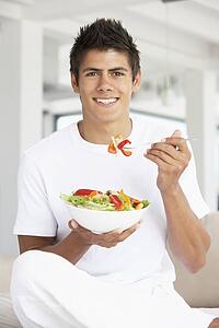 Young Man Eating A Salad