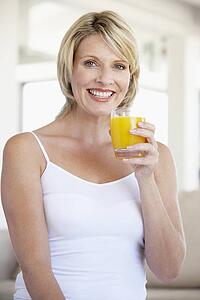Mid Adult Woman Drinking Orange Juice