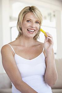 Mid Adult Woman Smiling At Camera And Eating Pineapple