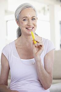 Senior Woman Eating Pineapple