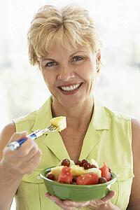 Middle Aged Woman Eating Fresh Fruit Salad