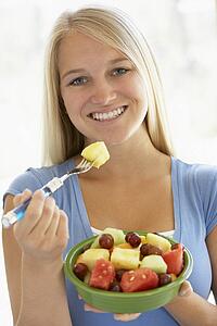 Teenage Girl Eating Fresh Fruit Salad