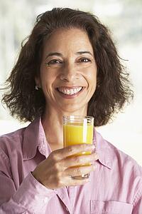 Middle Aged Woman Drinking Fresh Orange Juice