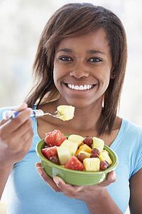 Teenage Girl Eating Fresh Fruit Salad