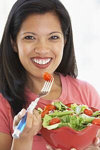Mid Adult Woman Holding A Bowl Of Salad, Smiling At The Camera