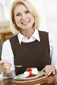 Senior Woman Eating Cheesecake