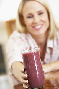 Mid Adult Woman Holding A Fresh Berry Smoothie