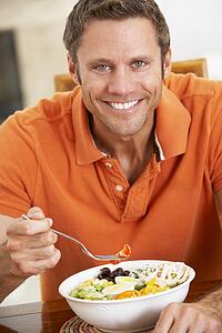 Middle Aged Man Eating A Healthy Meal, Smiling At The Camera