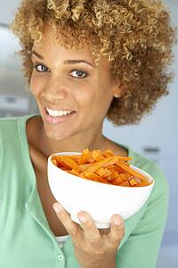 Mid Adult Woman Holding A Bowl Of Carrots