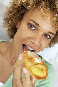 Mid Adult Woman Eating A Pastry