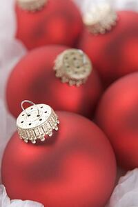 Group Of Red Christmas Tree Decorations Wrapped In Tissue Paper