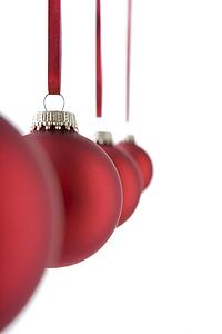 Line Of Red Christmas Decorations Hanging Against White Background