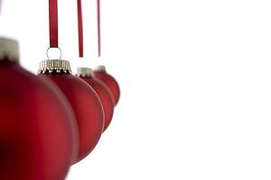 Line Of Red Christmas Baubles Against White Background