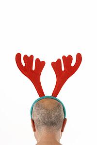 Man Wearing Reindeer Antlers Against White Background