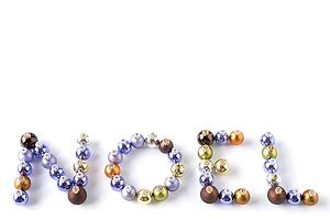 Coloured Baubles Spelling Out Word Noel Against White Background
