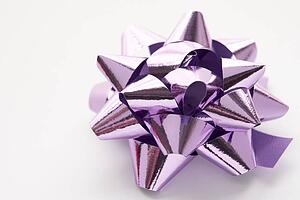 Purple Gift Wrap Bow Against White Background