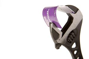 Credit Card Being Held In Wrench Against White Background