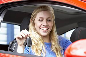 Teenage Girl Sitting In Car, Holding Car Keys And Smiling At The Camera