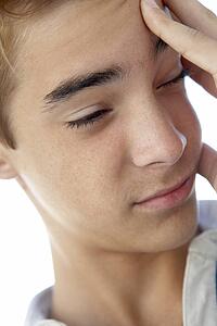 Portrait Of Teenage Boy Rubbing Temples