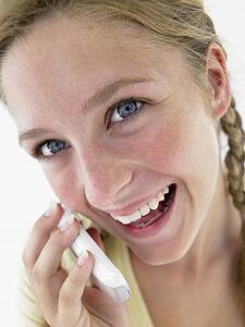 Portrait Of Teenage Girl Smiling And Talking On Cellphone