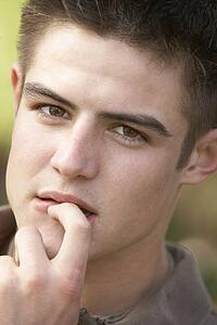 Portrait Of Teenage Boy Biting Nails