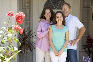 Family Standing Outside House