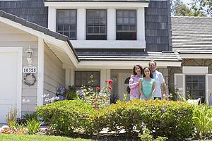 Family Standing Outside House