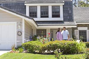Couple Standing Outside Their House