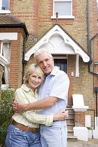 Couple Standing Outside Their House