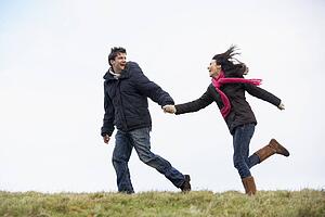 Couple Holding Hands And Running In The Park