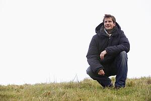 Man Crouching In Park