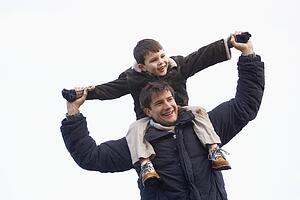 Father Carrying Son On His Shoulders