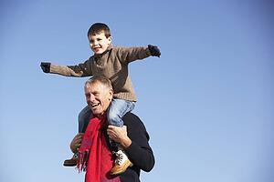 Grandfather Carrying Grandson On His Shoulders