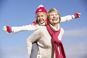 Grandmother Giving Her Granddaughter A Piggy Back Ride