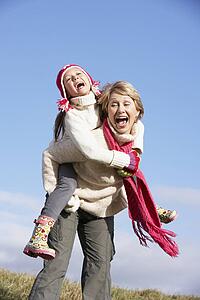 Grandmother Giving Her Granddaughter A Piggy Back Ride
